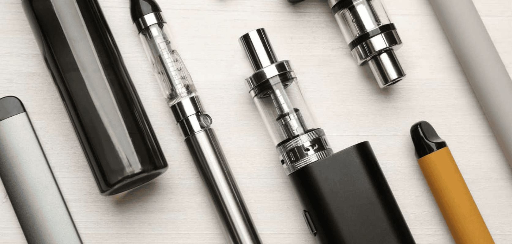 Various THC vape devices including cartridges, pens, and disposables on a table