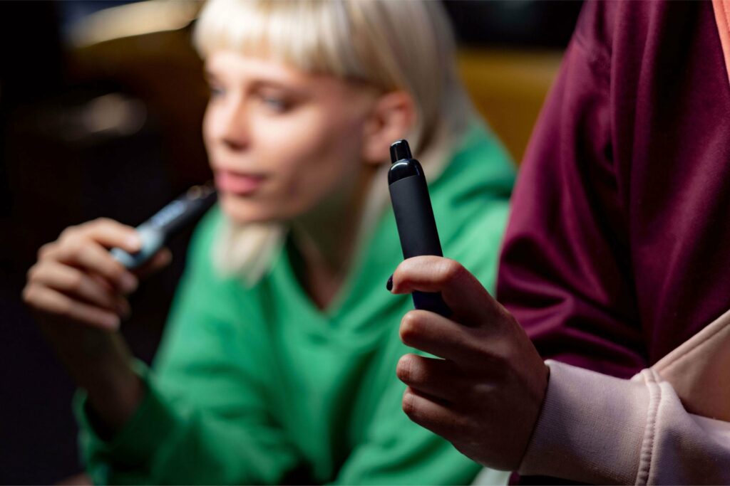 Two people holding and comparing different vape pen for THC, demonstrating decision-making between device options